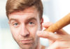 man posing while smoking a cigar