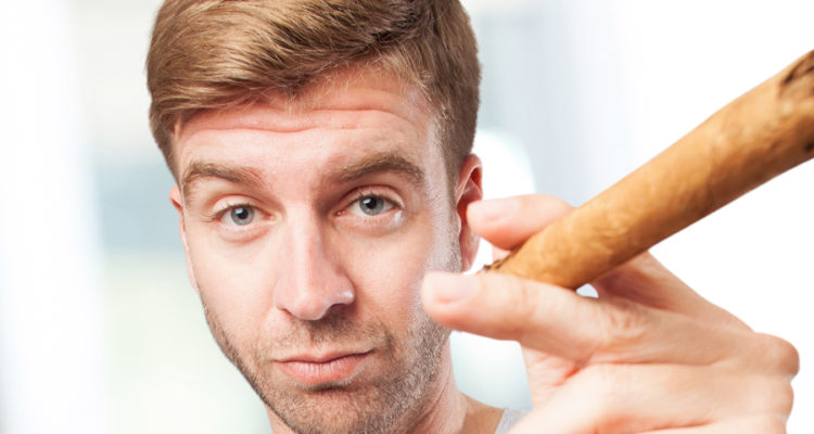 man posing while smoking a cigar