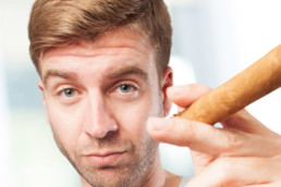 man posing while smoking a cigar